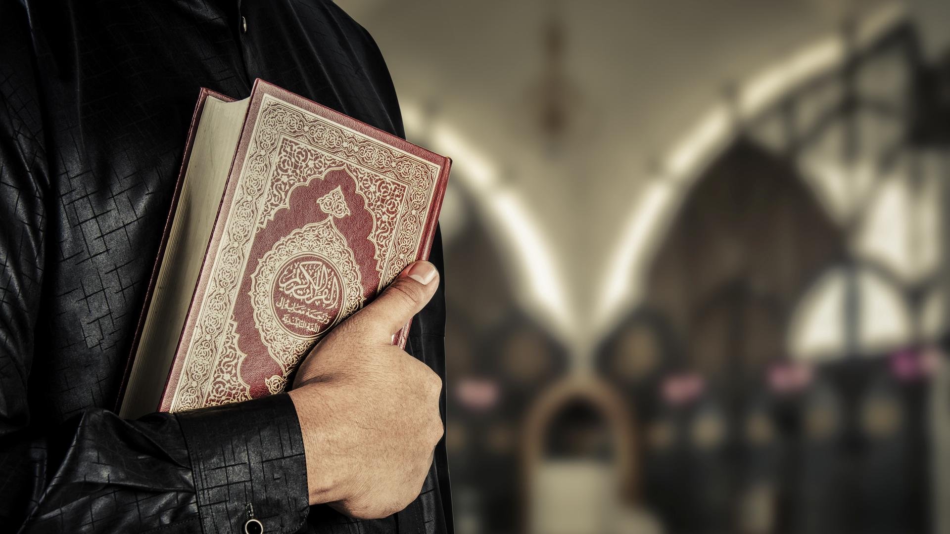 Послушать мусульманский. Мусульманин с Кораном. Мужчина с Кораном. Коран в руках.