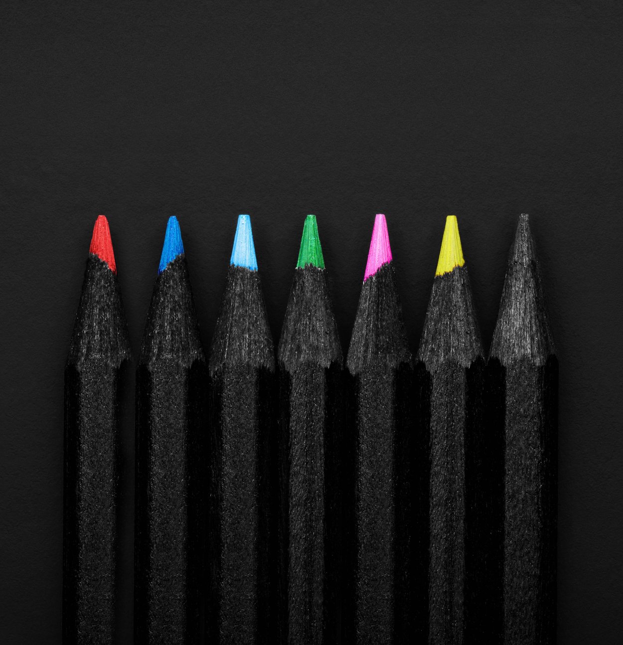 Карандаши и ручки на черном фоне